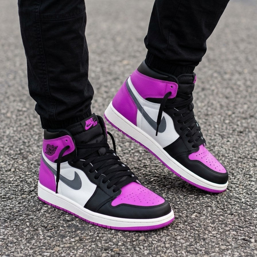Black, purple, and white sneakers on a person's feet on a gray pavement background