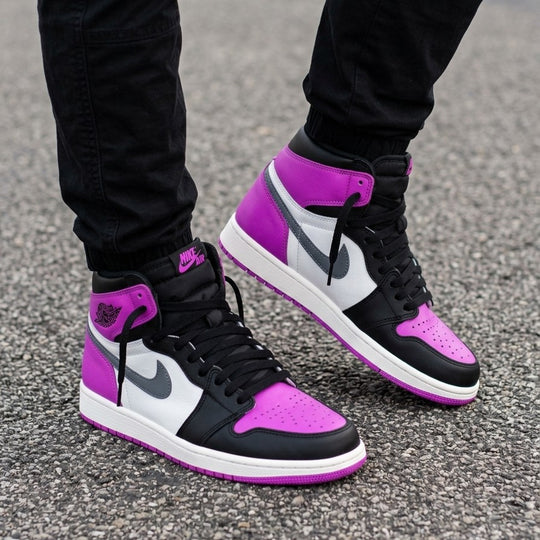 Black, purple, and white sneakers on a person's feet on a gray pavement background