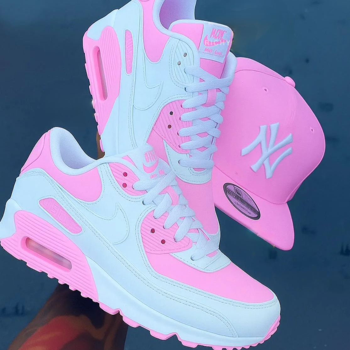 Pink and light blue air max 90 sneakers with a matching cap on a dark background